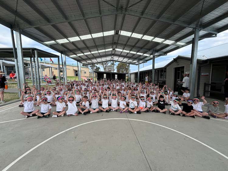 Whole school having a photo whilst sitting in the COLA